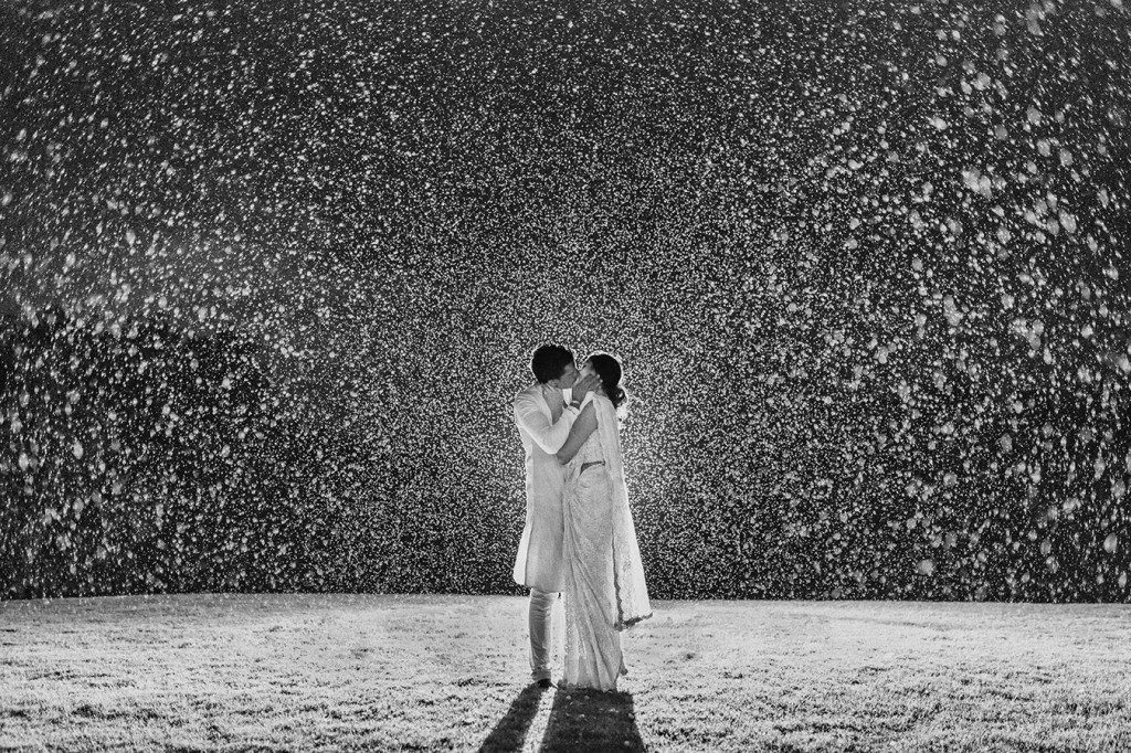 Wedding couple kissing in the rain